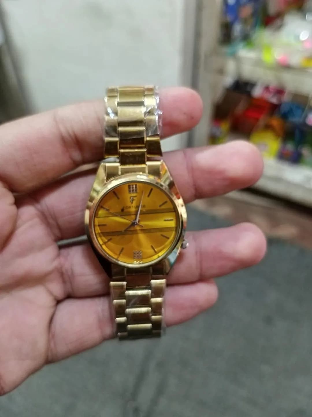 Gold Analog Wristwatch with Striped Dial & F Logo